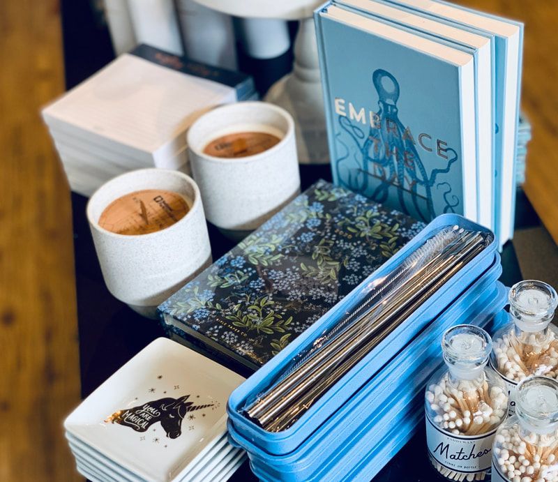 Handmade soaps, candles, and notebooks arranged on a table at a craft display.