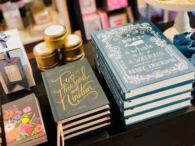 Stacked decorative books and candle jars on a tabletop display