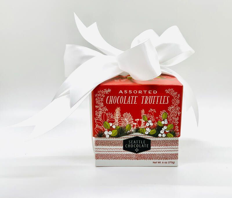 Assorted chocolate truffles in a red and white gift box with a large white bow