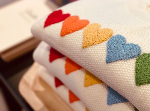 Folded towels with colorful embroidered hearts in red, orange, yellow, blue, and green
