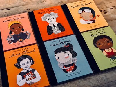 Six colorful illustrated book covers arranged in a grid on a wooden surface