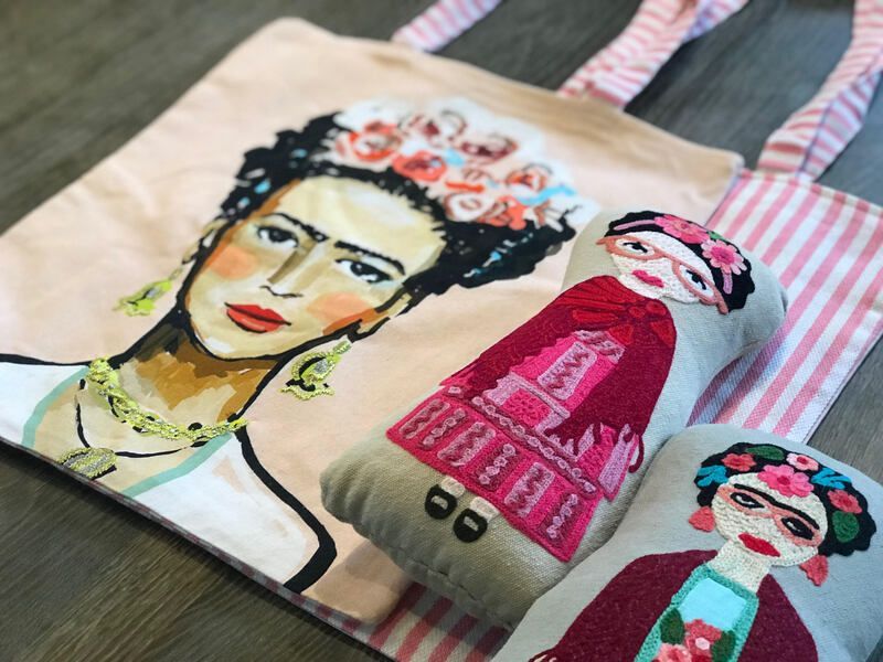 Canvas tote bag with painted Frida Kahlo portrait and two colorful floral-dressed dolls