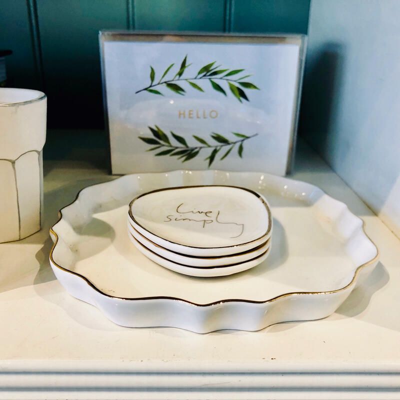 Decorative tray with small stacked soaps and a “HELLO” box with green leaf design on a shelf