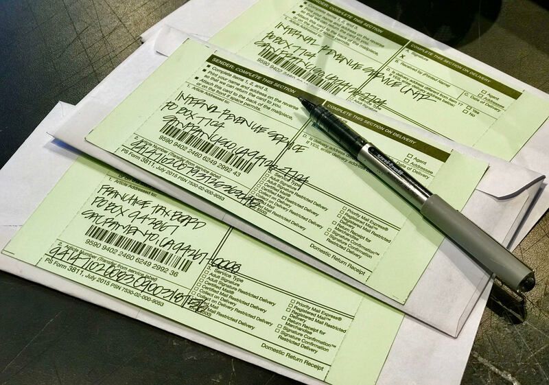 Forms on a desk with a pen laid across them