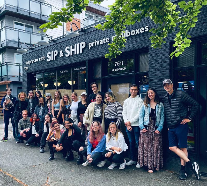 Group posing outside SIP & SHIP private mailboxes storefront on a city street
