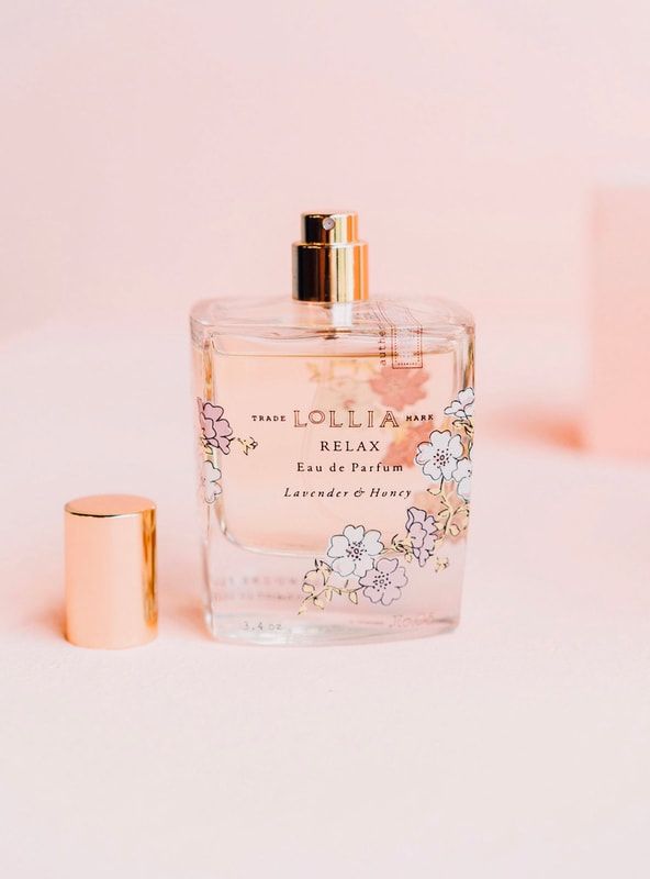 Pink floral perfume bottle with gold cap on a pastel background