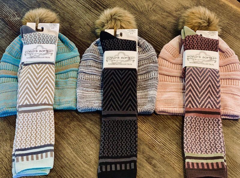 Four pairs of patterned winter boots with fur cuffs lined up on a furry surface