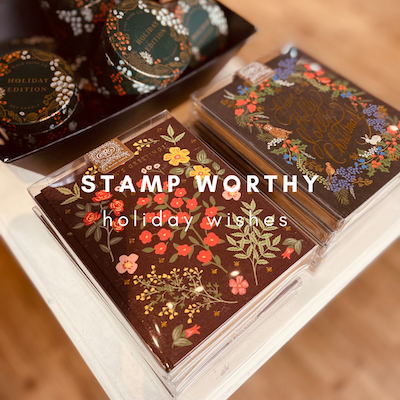 Holiday card with floral design and “STAMP WORTHY holiday wishes” text on a wooden table