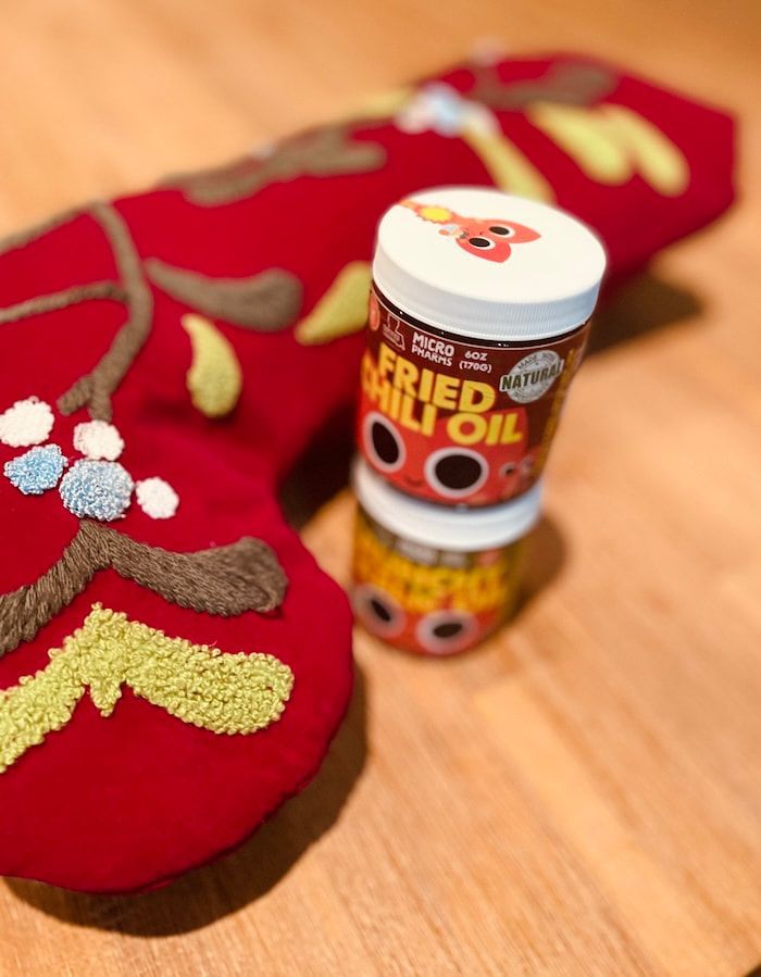 Holiday-themed red fabric items beside a small canister on a wooden surface