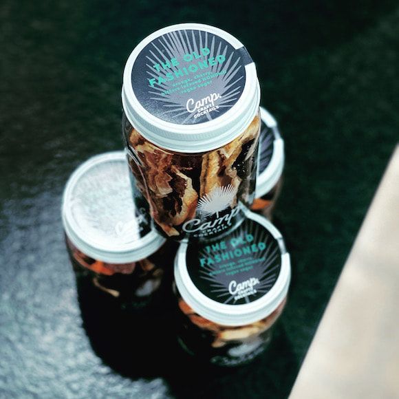 Stacked clear cans with dark labels on a dark surface, top view