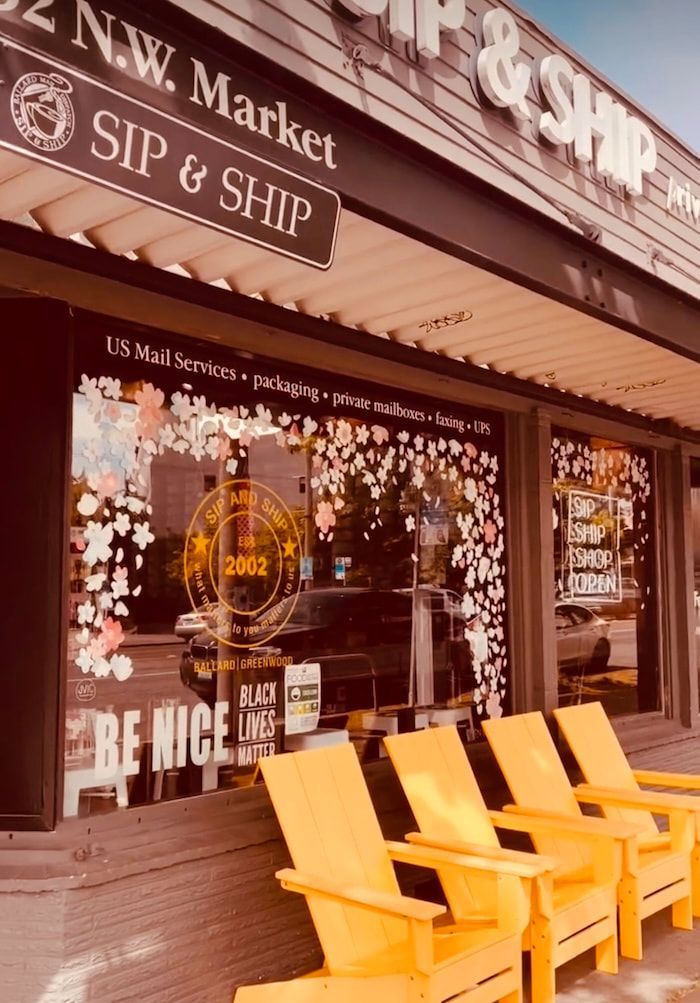 Storefront with “Sip & Ship” sign and yellow chairs outside on a sidewalk.