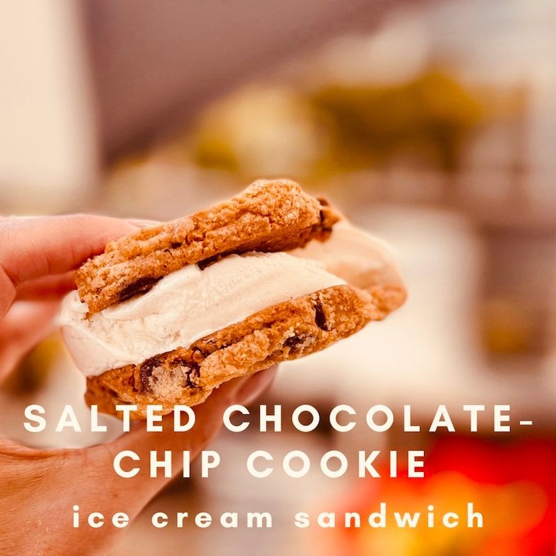 Salted chocolate-chip cookie ice cream sandwich held in a hand, with text overlay.