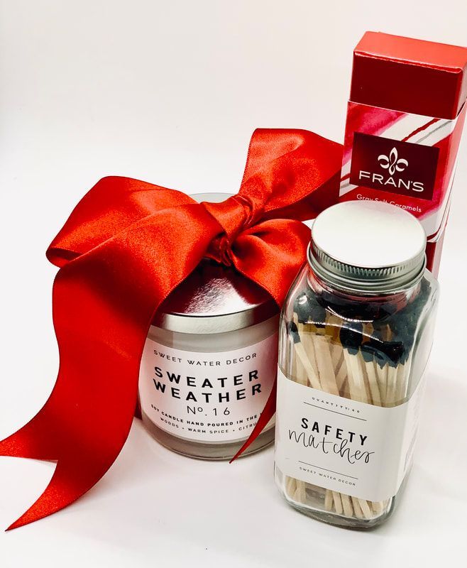 Red gift set with a bow, jar candles, and a small box on a white background