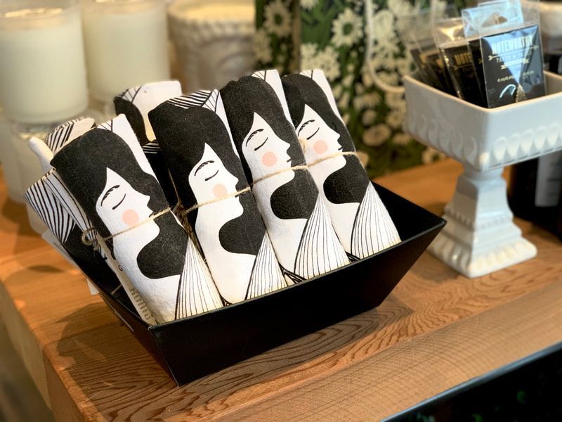 Tray of cat-shaped treats on a wooden table with candles and a decorative stand in the background
