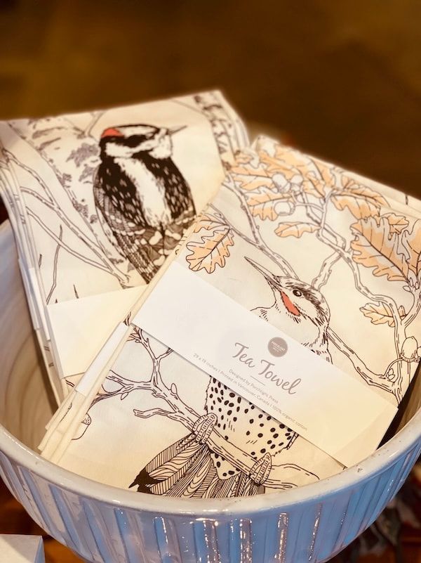 Blue bowl holding illustrated “Fine Feather” cards with bird and botanical drawings