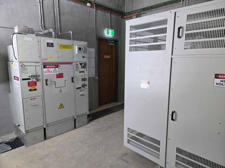 A room with a lot of electrical boxes and a door.
