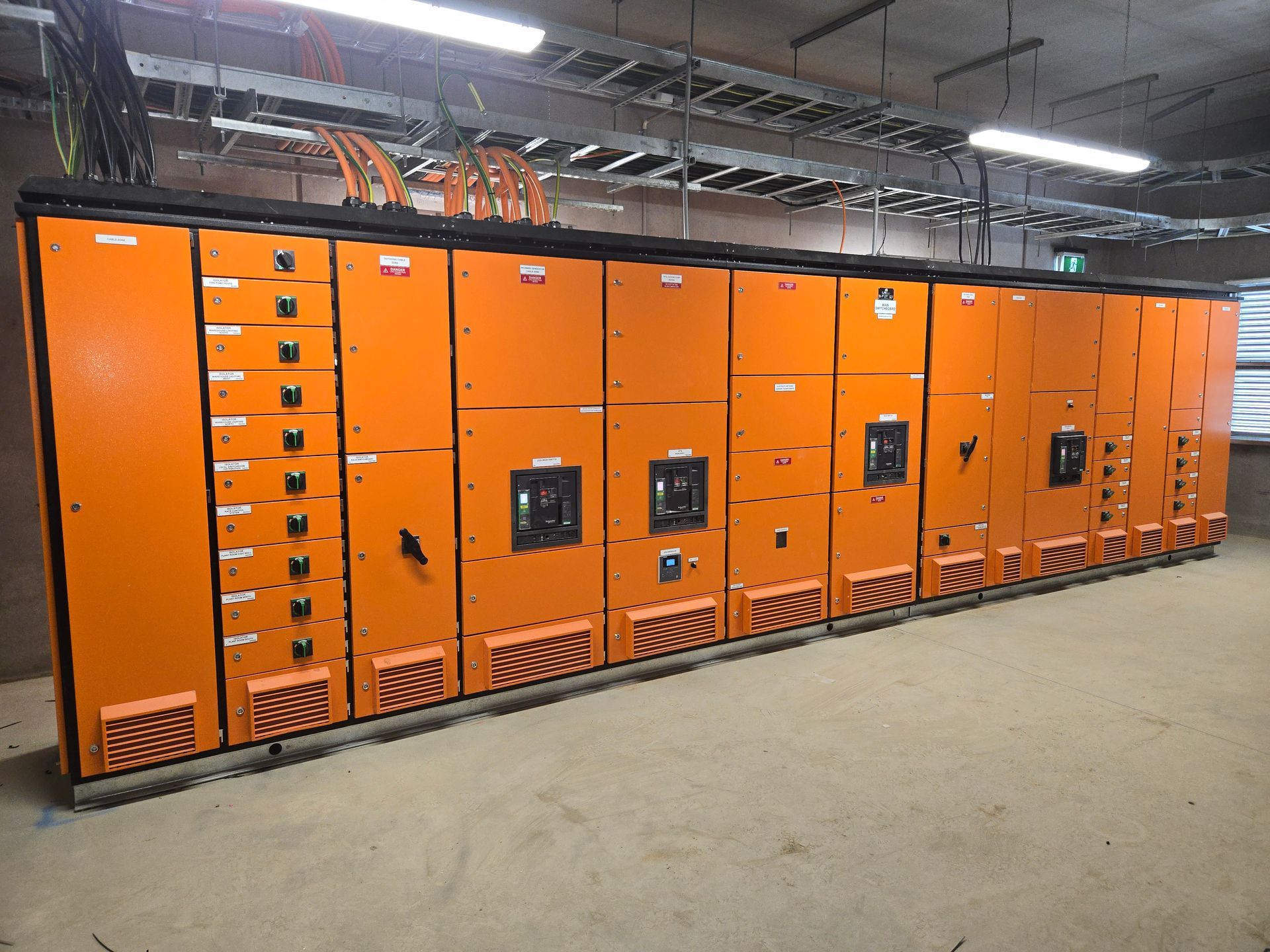 A row of orange electrical boxes in a room
