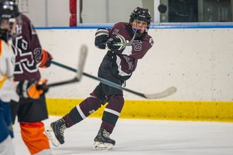 Henderson Warriors player in a maroon home jersey takes a shot