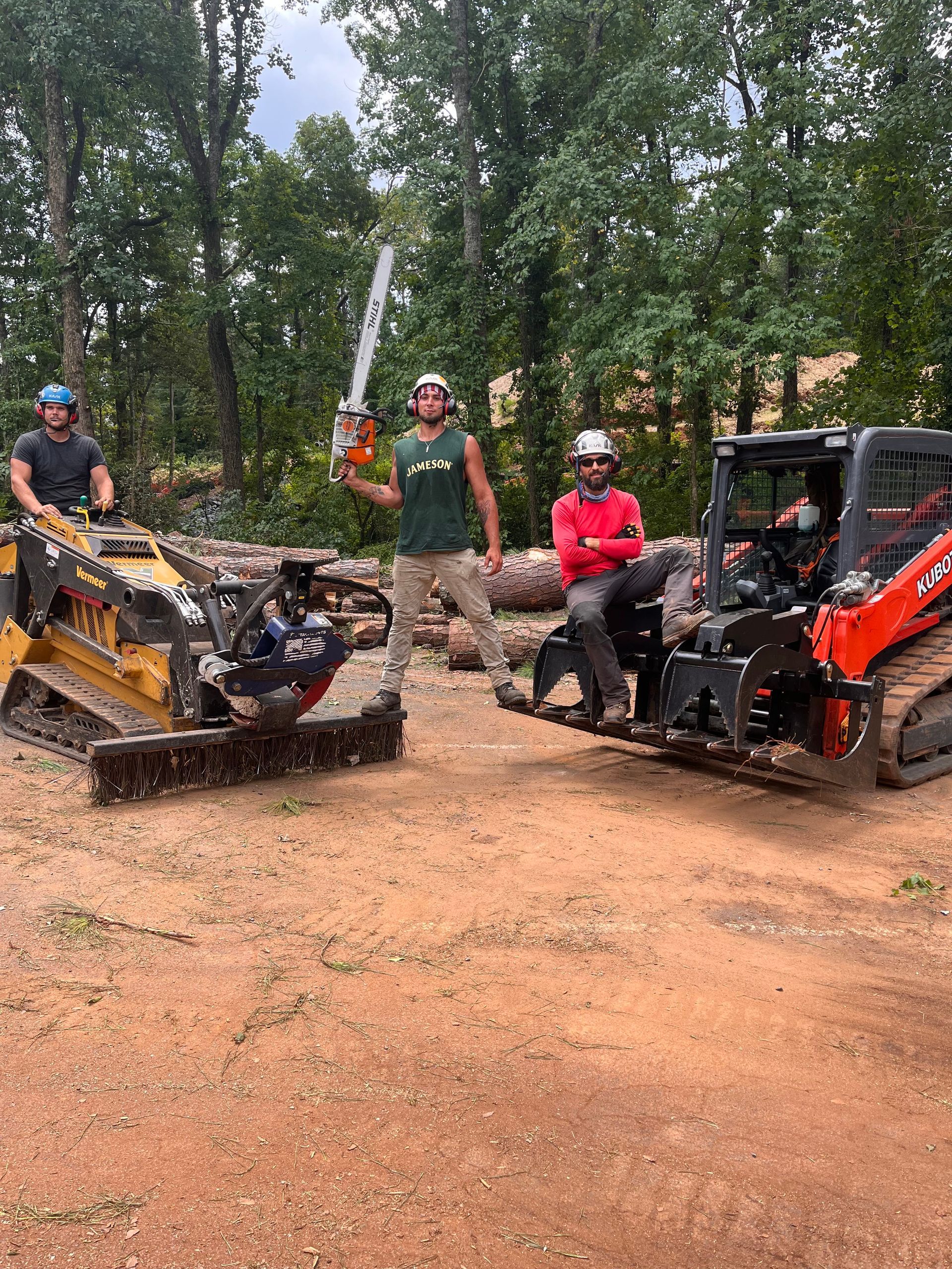 A group of men are standing next to each other holding chainsaws.