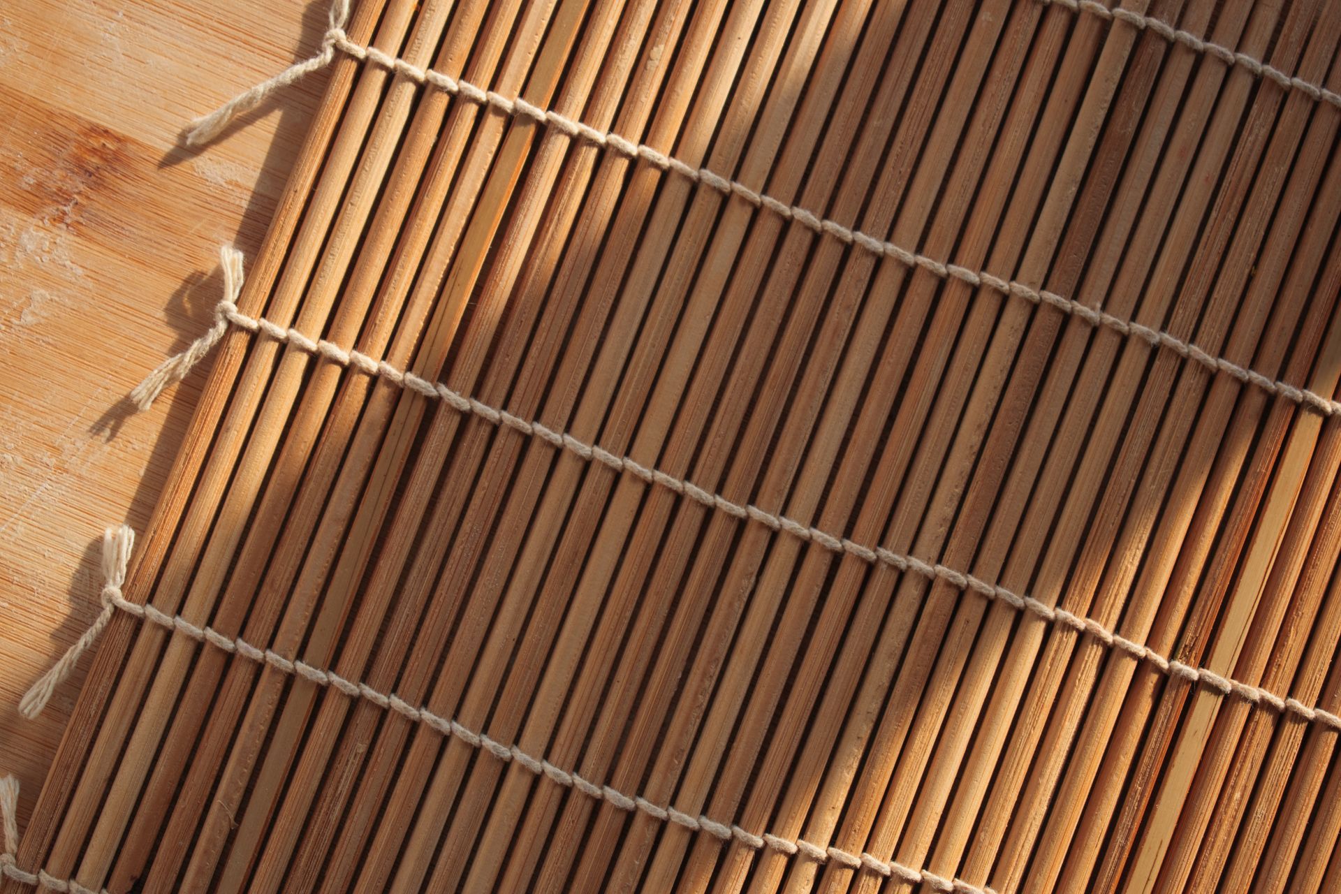 Close-up of a brown slatted wooden surface with diagonal metal rails against a stone wall. Close-up of a brown slatted wooden surface with diagonal metal rails against a stone wall.
