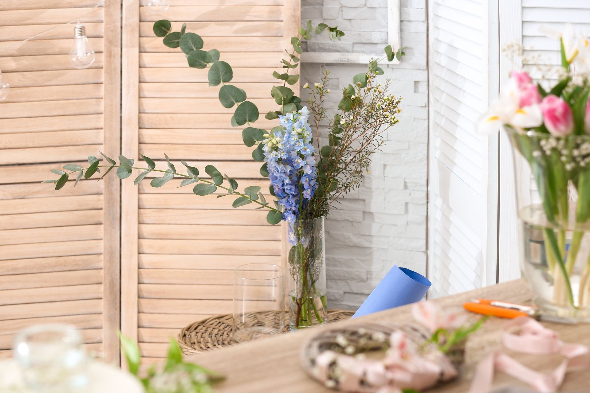 Cozy tabletop with flowers, eucalyptus branches, and pastel decor in a bright white room Cozy tabletop with flowers, eucalyptus branches, and pastel decor in a bright white room