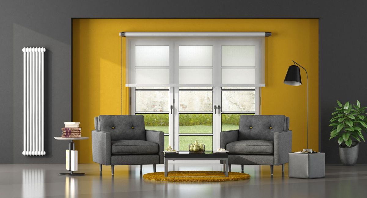 Modern living room with yellow accent wall, gray chairs, large window, rug, and floor lamp. Modern living room with yellow accent wall, gray chairs, large window, rug, and floor lamp.