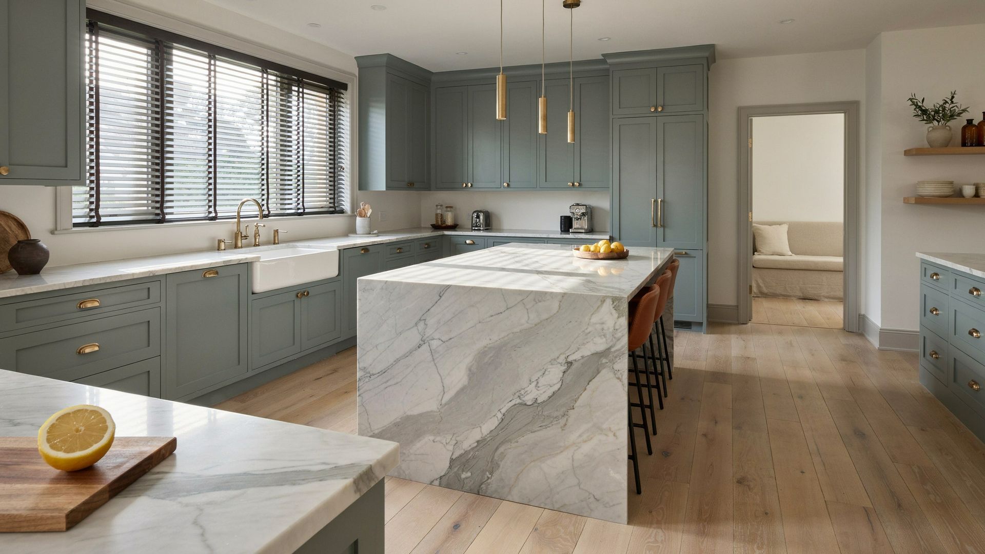Bright modern kitchen with blue cabinets, wood blinds, marble island, and wood floors