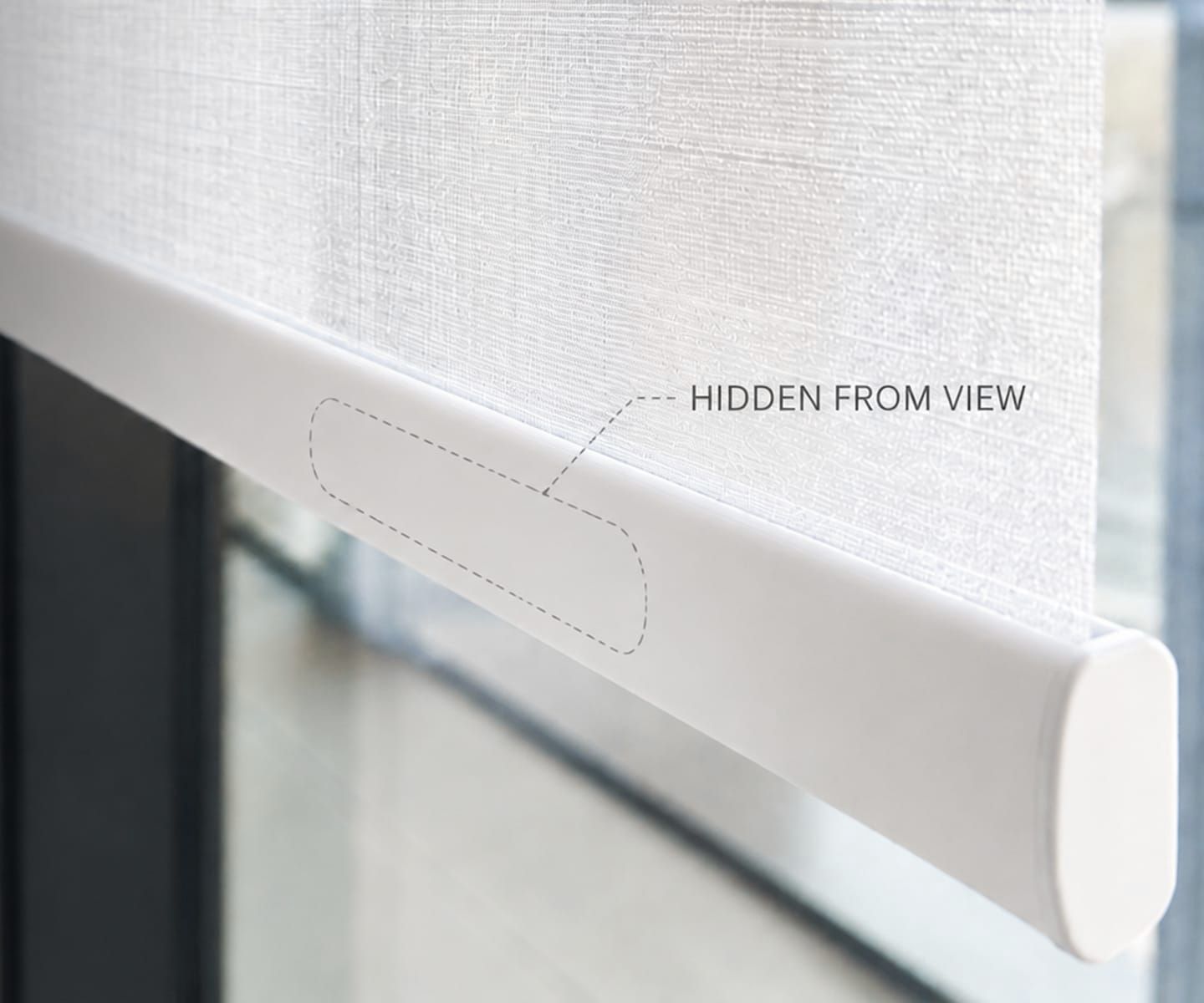 White roller blind with hidden mounting bracket by a window