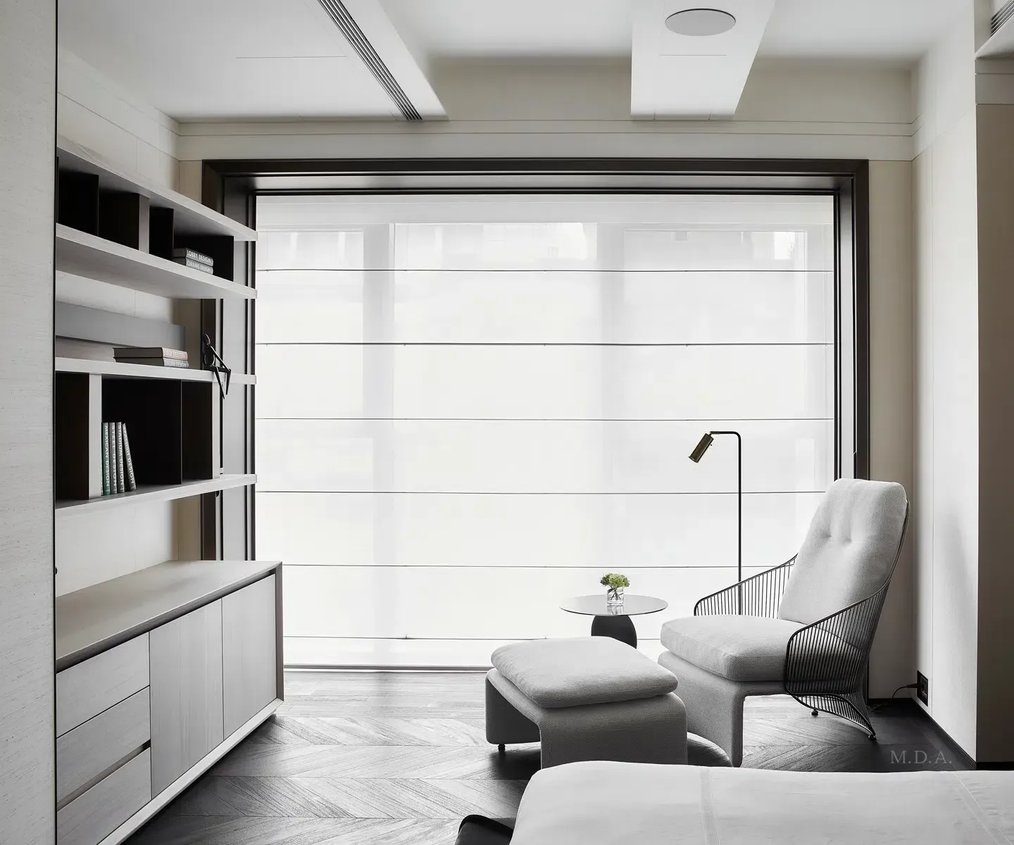 Bright minimalist living room with a sofa, chair, ottoman, floor lamp, and large window shades