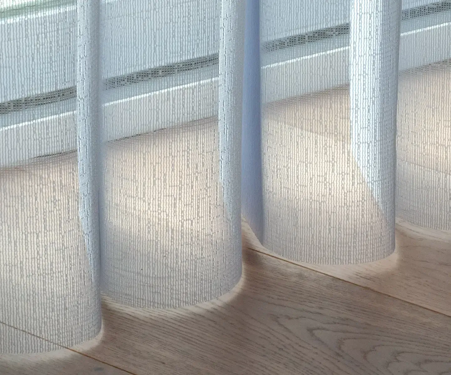 Sheer curtains and vertical blinds above a light wood floor, with sunlight filtering through