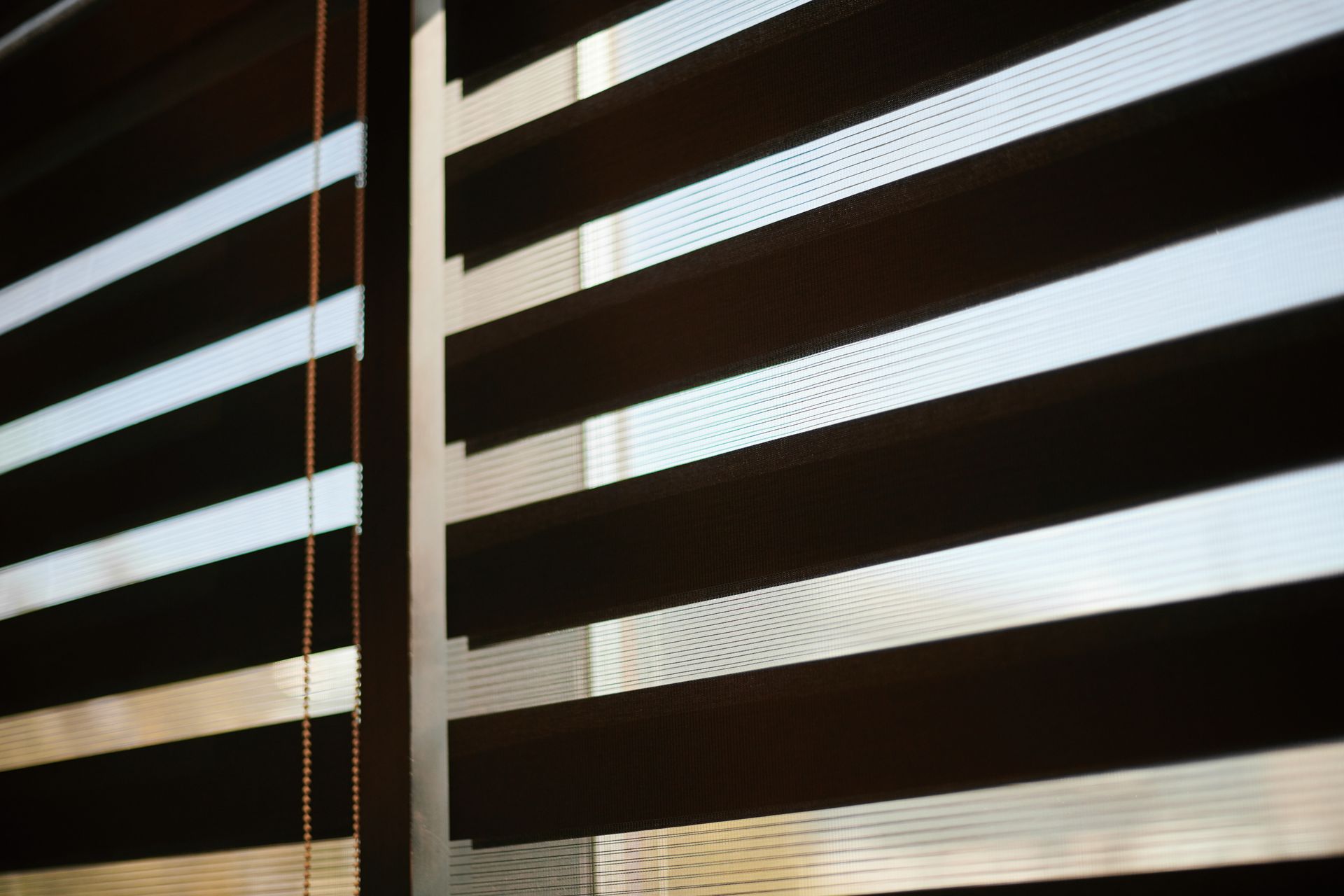 Sunlight filtering through partially closed horizontal blinds, casting striped shadows Sunlight filtering through partially closed horizontal blinds, casting striped shadows