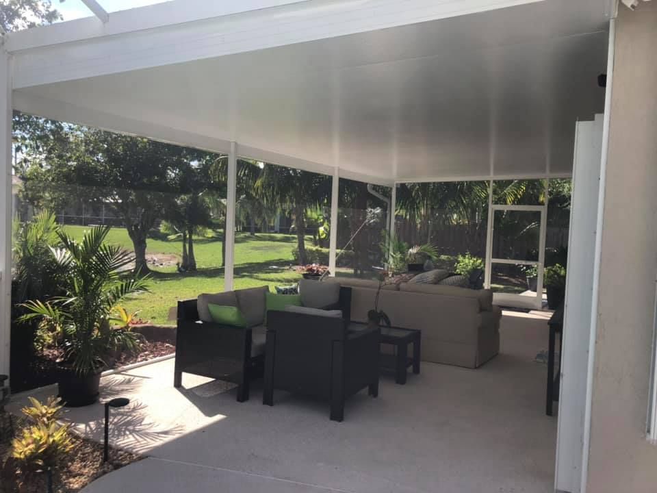 A patio with a table and chairs under a covered patio cover.