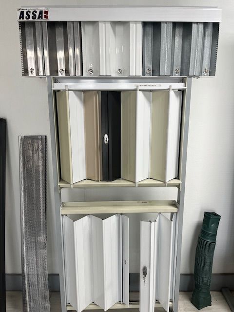 Display of assorted white, gray, and green folding screens or panels in a showroom