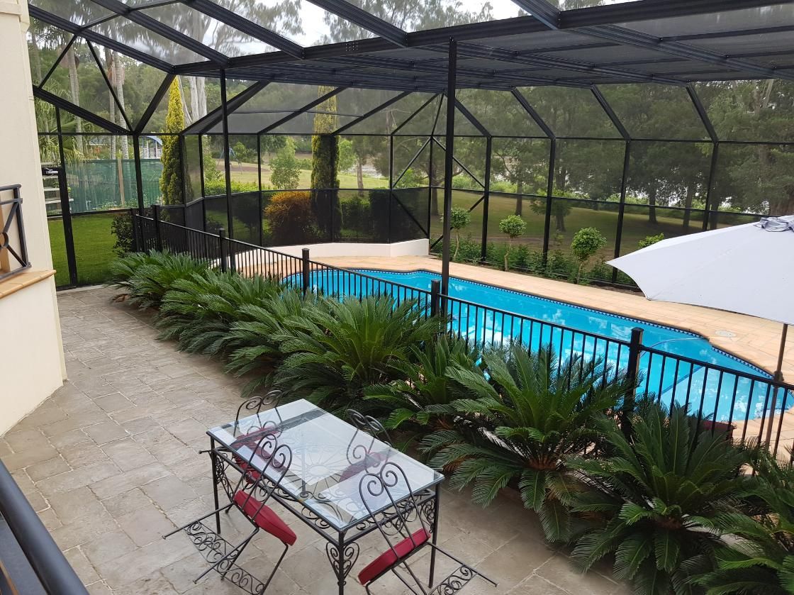 A swimming pool with a table and chairs in front of it