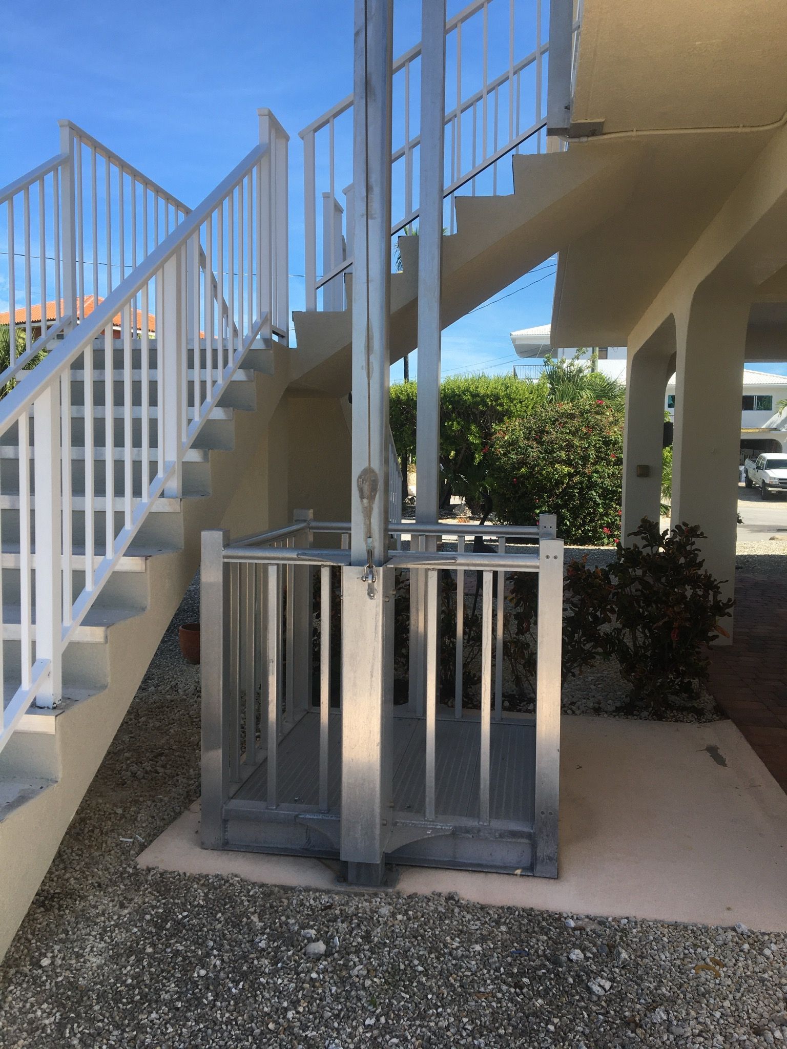 Outdoor staircase beside a metal bicycle rack under a building walkway