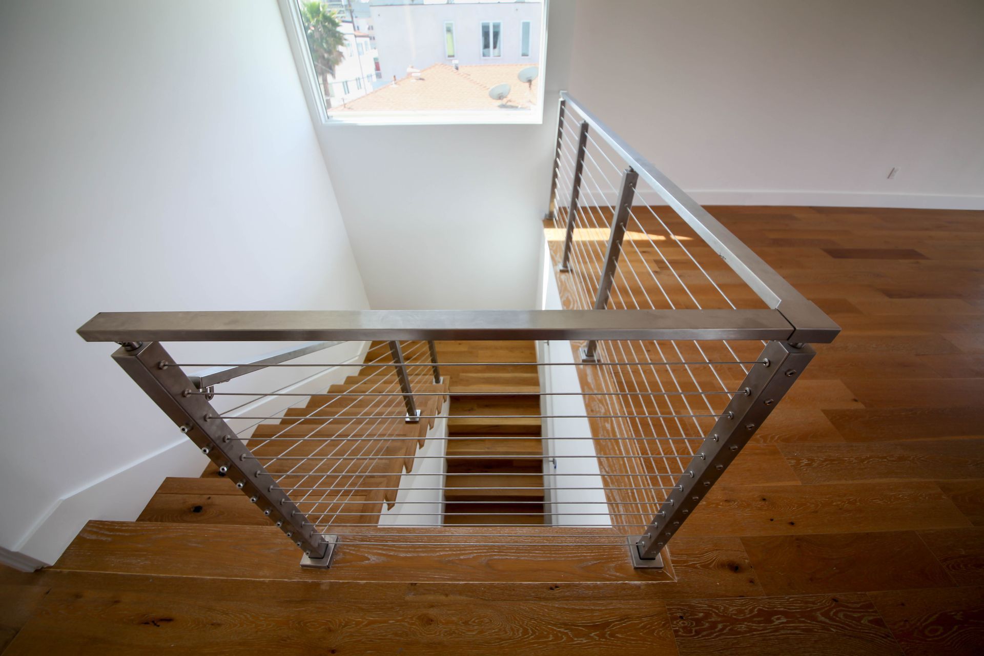 Looking down a staircase with a wrought iron railing.