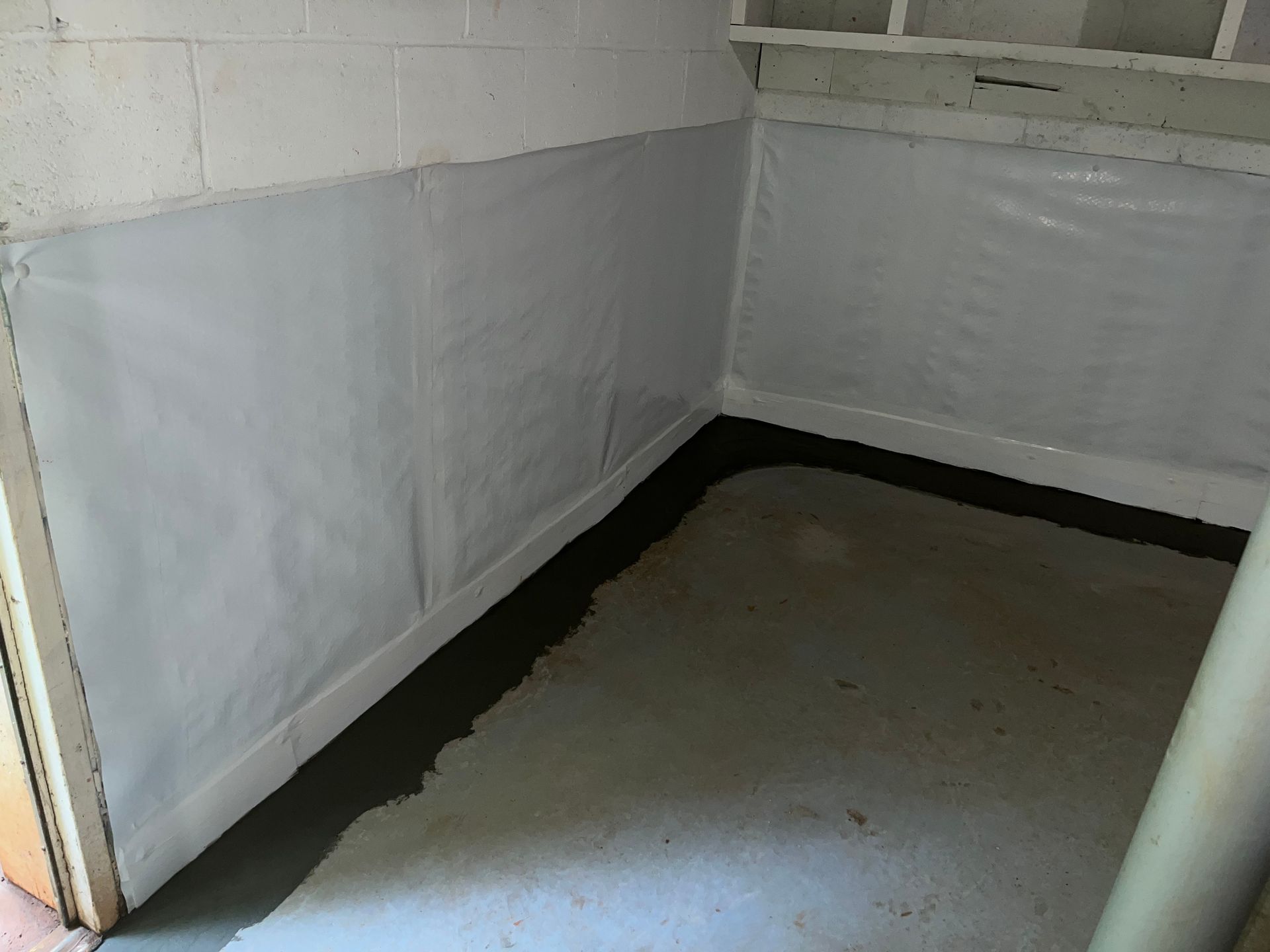 Empty basement corner with gray painted walls and a concrete floor
