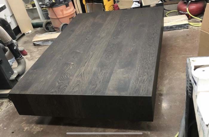 Dark stained wooden coffee table in a workshop setting.