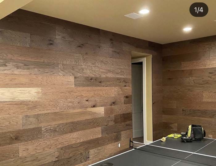 Wood paneled wall with a door frame and ping pong table.