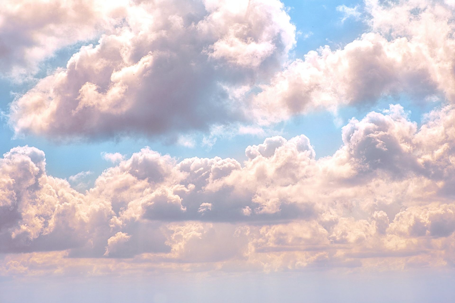 Soft pink clouds in a blue sky at sunset