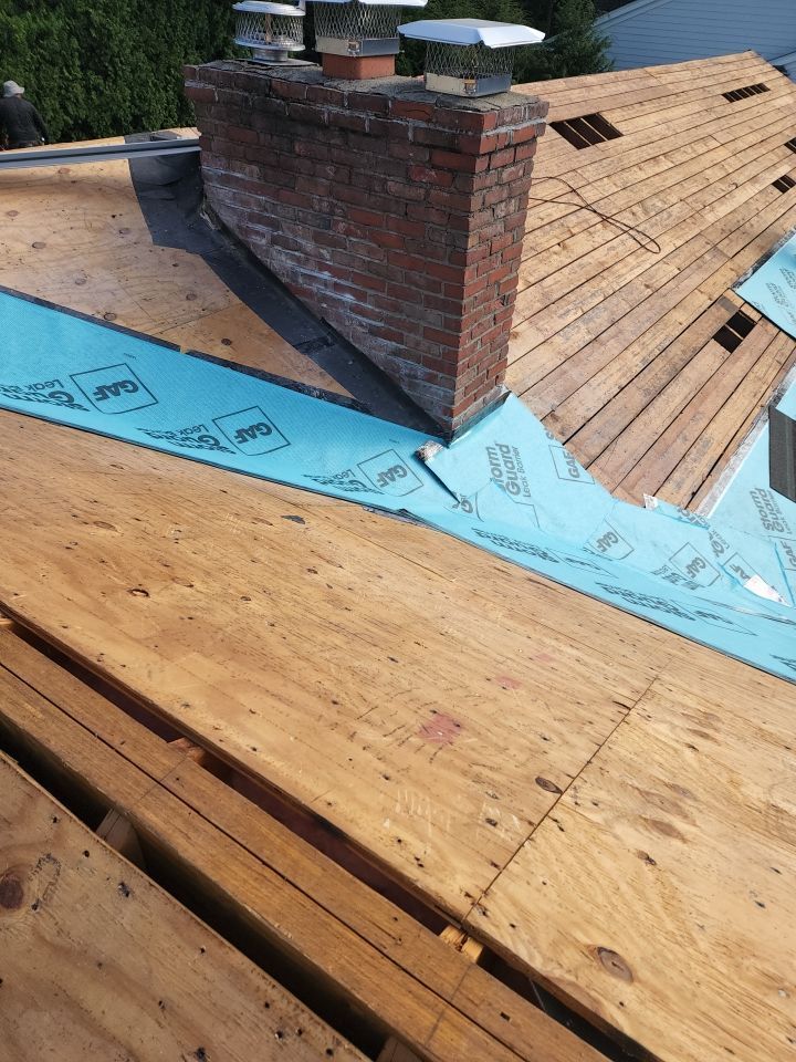 A wooden roof with a brick chimney on top of it.