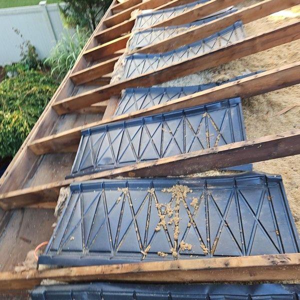 Rafter vent baffles installed between roof rafters to restore soffit intake airflow