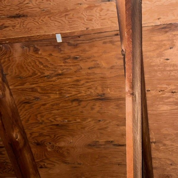 Water-damaged plywood roof decking viewed from the attic in Bellingham MA