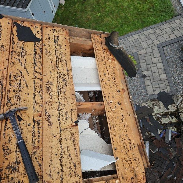 Gaps between original 1956 wood plank roof decking exposed during tear-off in Fitchburg MA