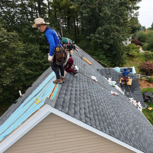 Master Roof crew wearing safety harnesses installing GAF Timberline UHDZ shingles over GAF StormGuard leak barrier on a Holliston MA Colonial