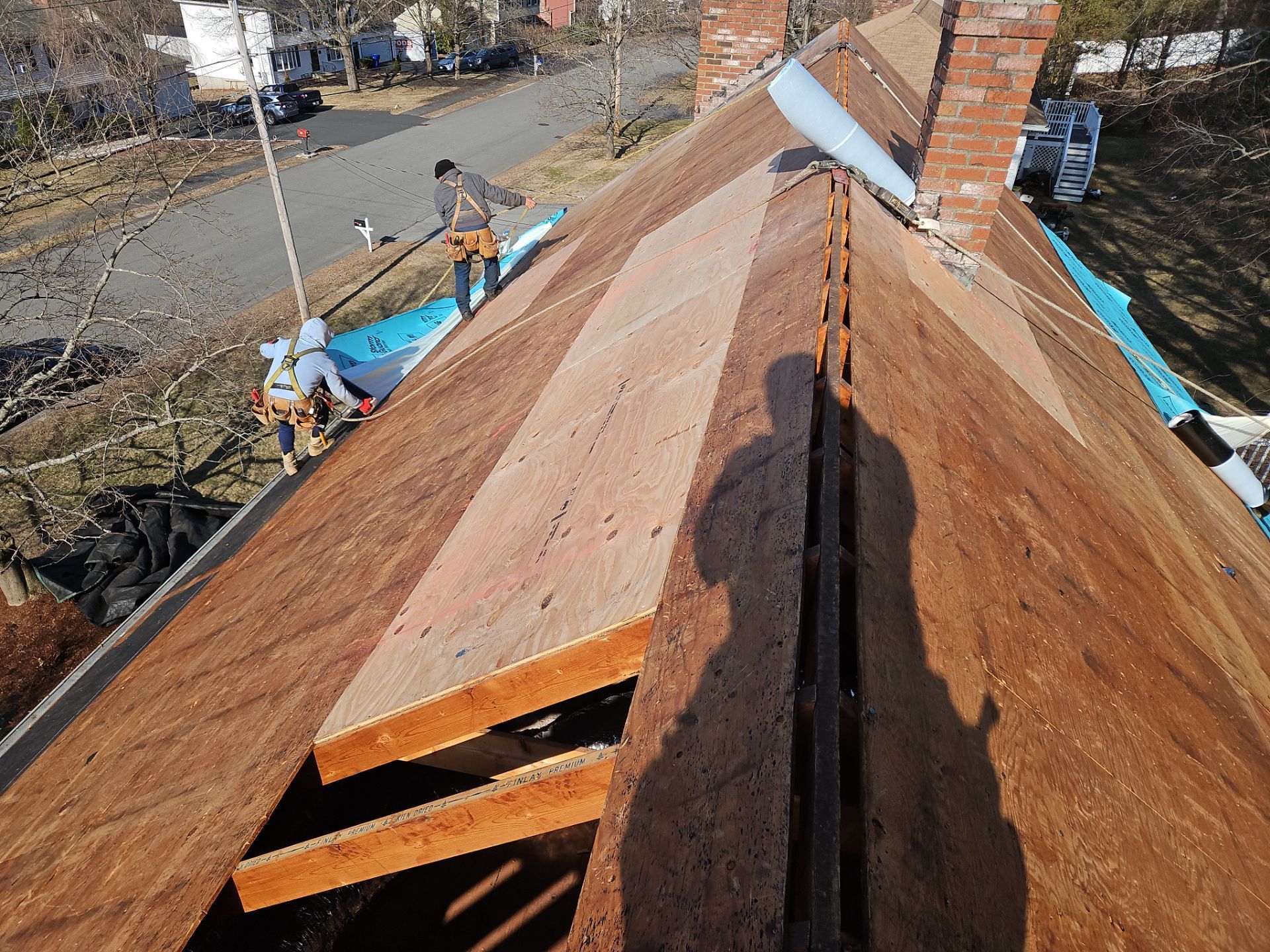 Rooftop with damaged sheathing under repair.