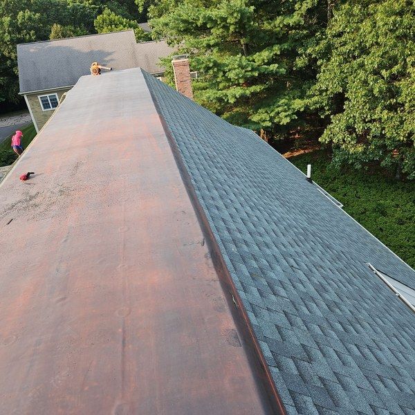 New low-slope membrane roof section meeting new asphalt shingles on a Medfield MA home