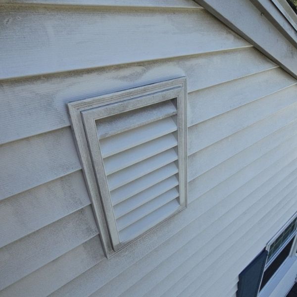 White house siding with a rectangular vent box.