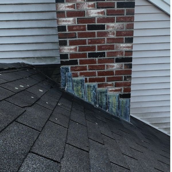 Chimney with weathered flashing and shingles.