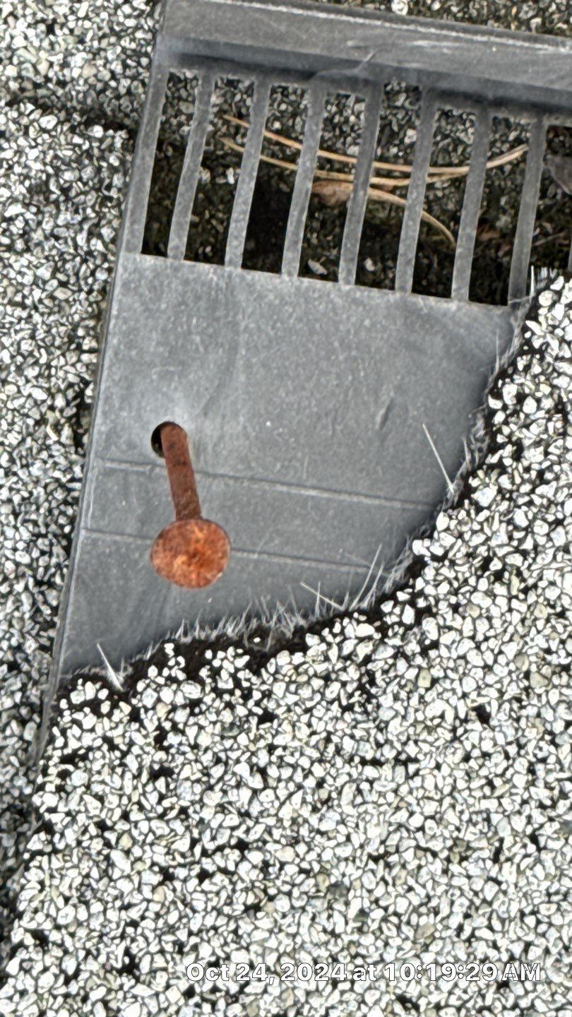 Broken shingle with rusting nail.